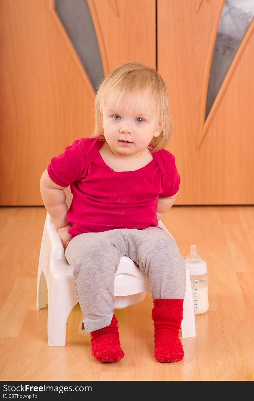 Adorable baby sit on baby chair toilet. Adorable baby sit on baby chair toilet