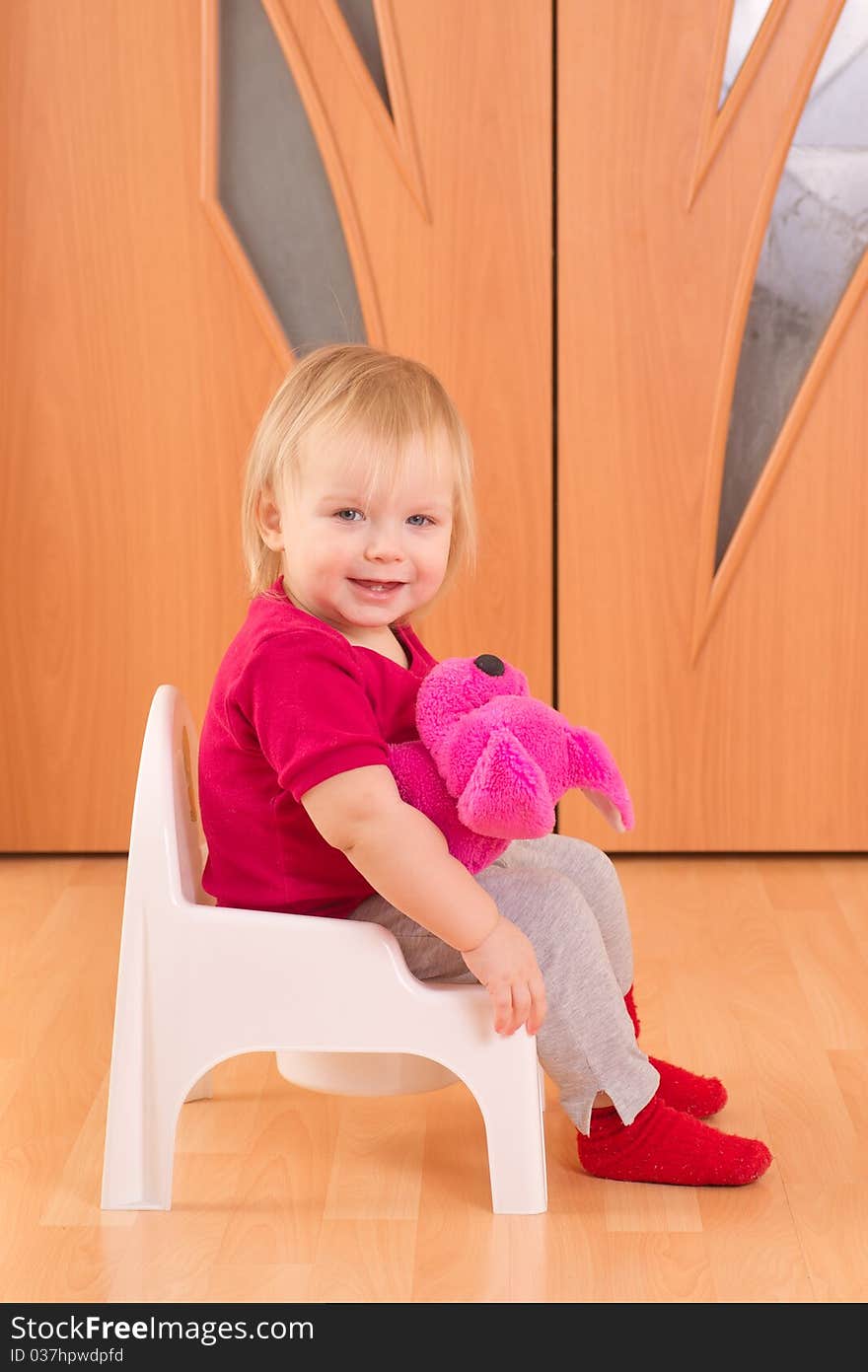 Adorable baby sit on toilet chair with cute pink toy dog. Adorable baby sit on toilet chair with cute pink toy dog