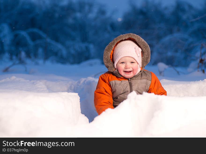 Adorable baby sit and digging hideout hole in snow