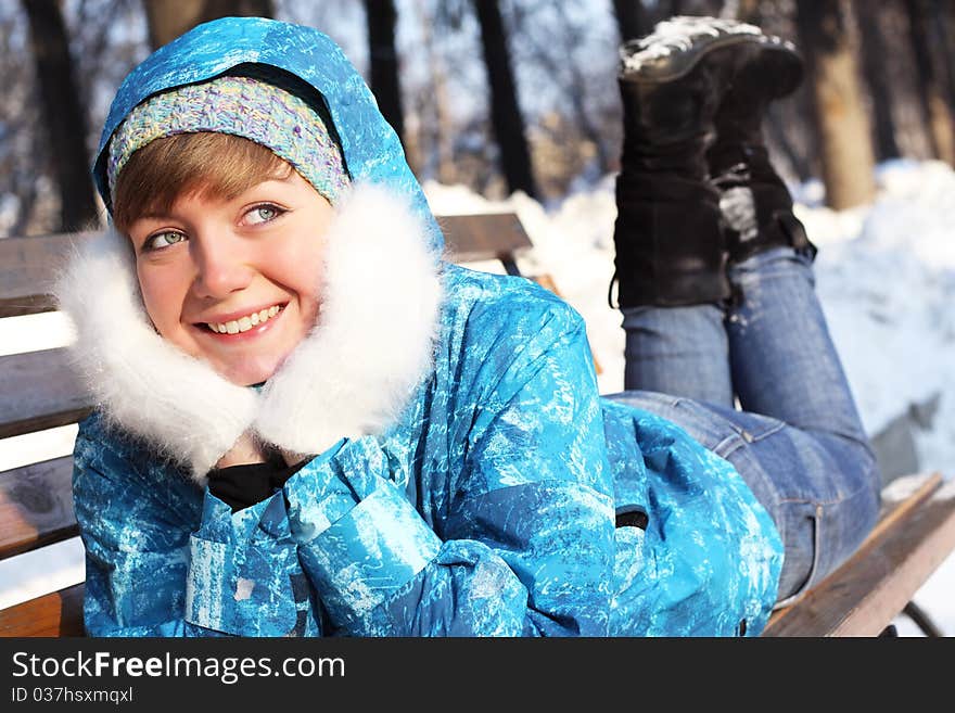 The girl lays on a bench. Winter entertainments