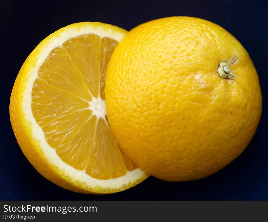 Two half oranges on a dark background