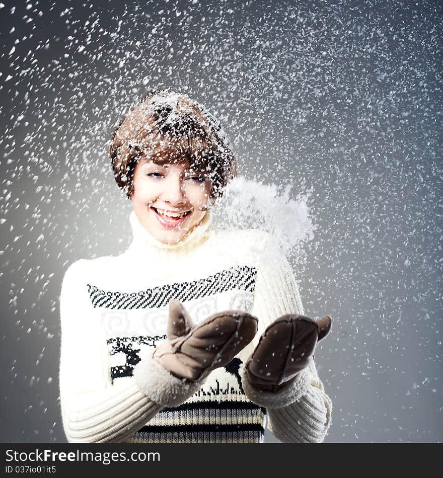 Young beautiful girl rejoices to snow, On a dark blue background