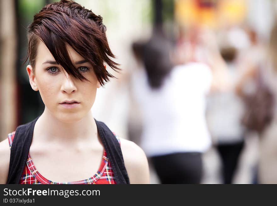 Young modern looking girl over urban background. Young modern looking girl over urban background