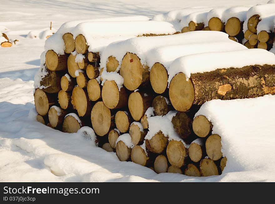 Wood piles in snow, traditional energy source