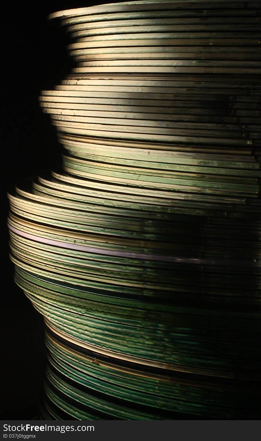 Closeup photo of stacked compact discs against a black background. Closeup photo of stacked compact discs against a black background.