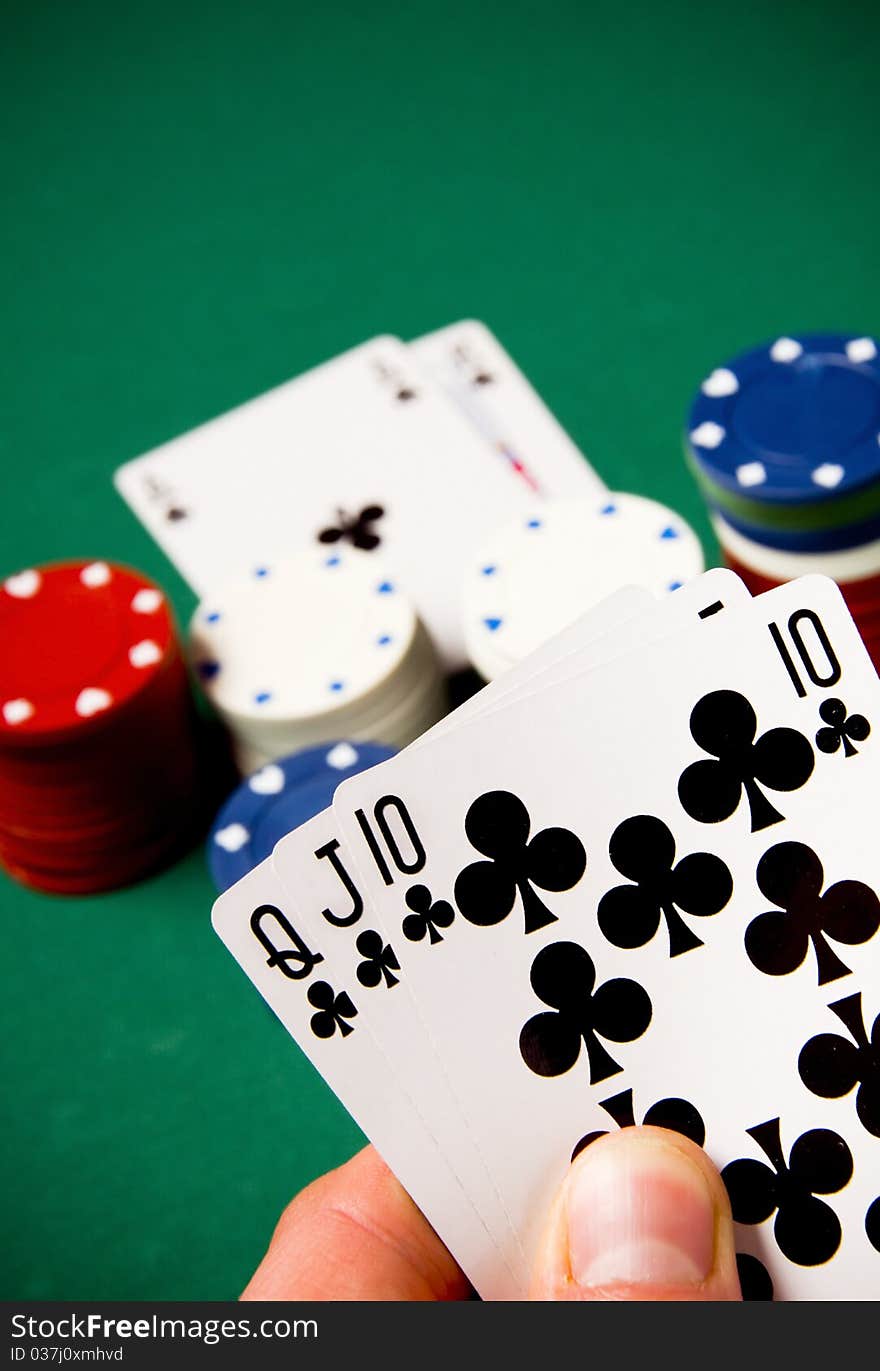 Playing cards and gambling chips on green background