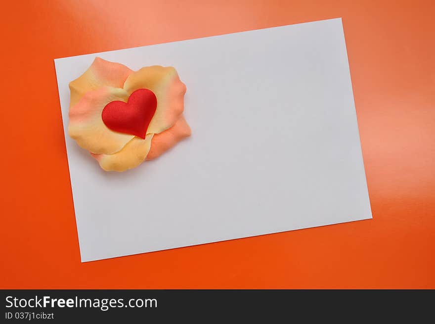 White card with rose petals. Postcard with heart on the orange background. White card with rose petals. Postcard with heart on the orange background.