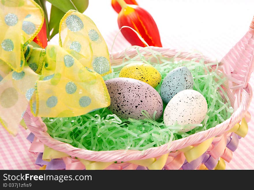 Easter blue, pink, yellow Painted Colorful eggs in basket with spring tulips on a pastel background. Easter blue, pink, yellow Painted Colorful eggs in basket with spring tulips on a pastel background