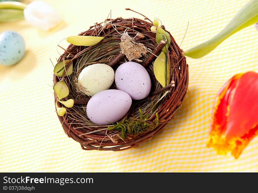 Easter eggs in birds nest decorated with tulip flower