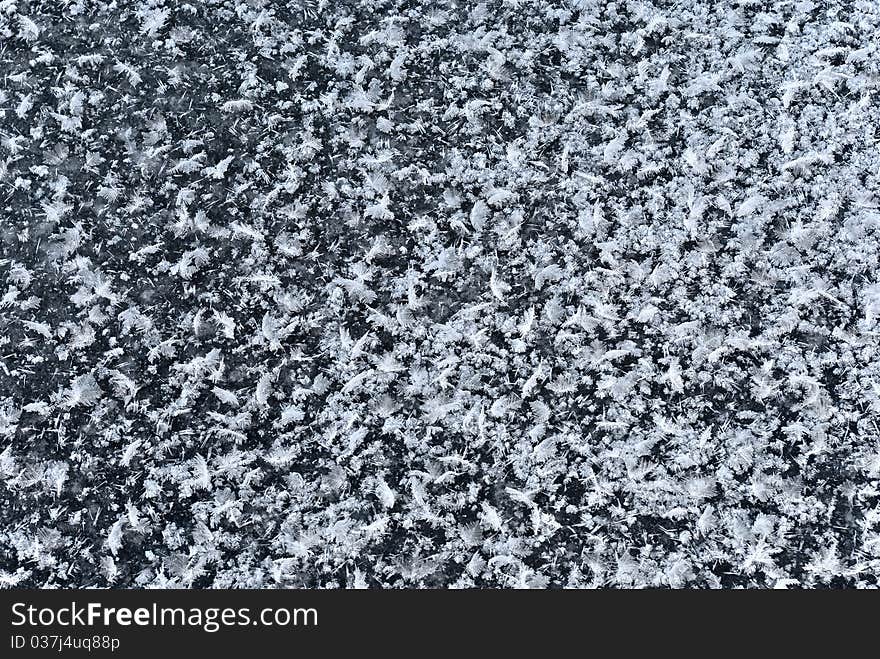 Abstract pattern of snow flakes on black ice similar to scattered bird's feathers. Abstract pattern of snow flakes on black ice similar to scattered bird's feathers