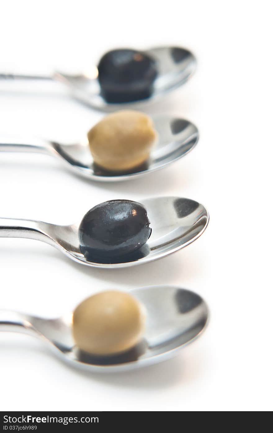 Green olives aligned on teaspoons