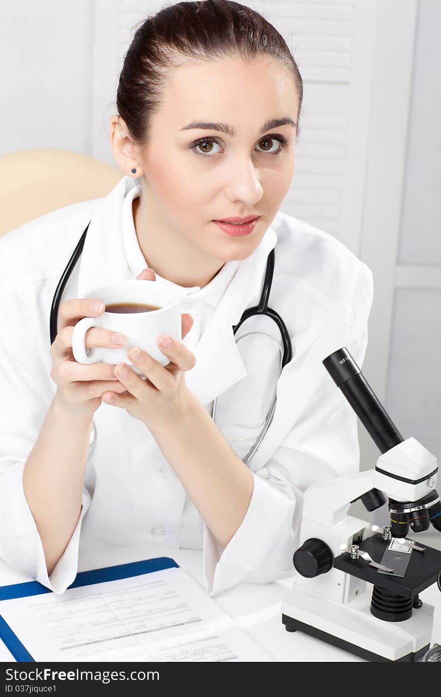 Female medical doctor working with a microscope. Female medical doctor working with a microscope