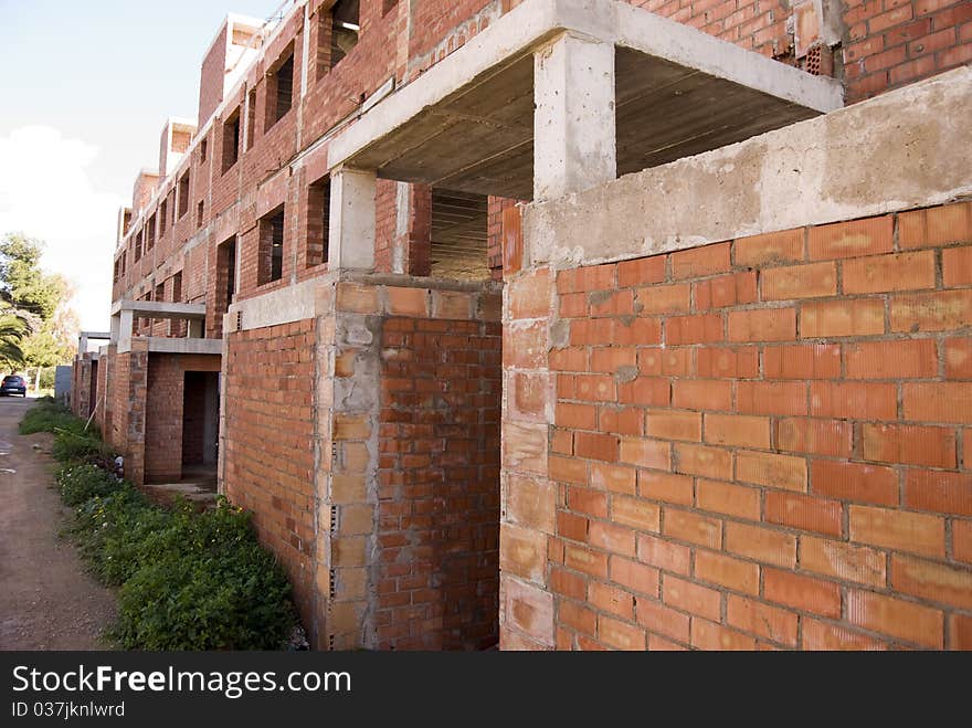 Building in red brick works unfinished by the crisis. Building in red brick works unfinished by the crisis