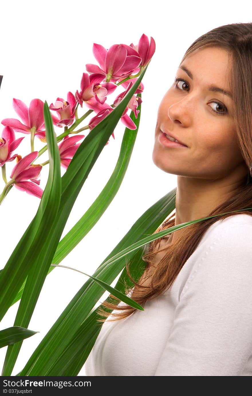 Brunette woman smelling purple orchid flower