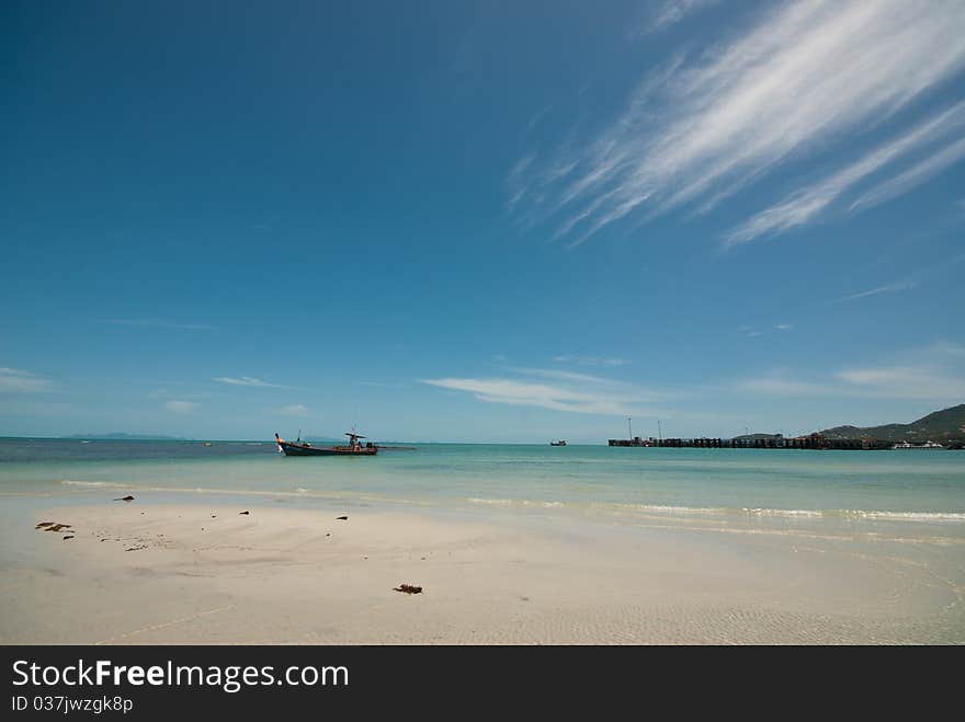 A long tail boat in the sea with blue sky day. A long tail boat in the sea with blue sky day.