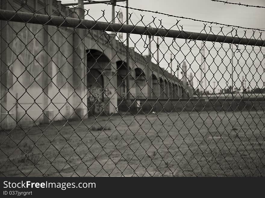 A bridge over the Los Angeles River, behind chain link fence. A bridge over the Los Angeles River, behind chain link fence.