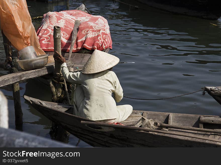 An old Vietnamese woman sits in a boat. An old Vietnamese woman sits in a boat.