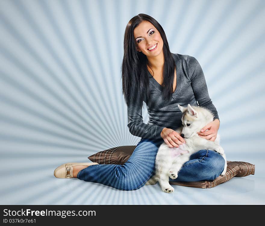 Playing woman with puppies of siberian haski on blue background with jalousie effect. Playing woman with puppies of siberian haski on blue background with jalousie effect