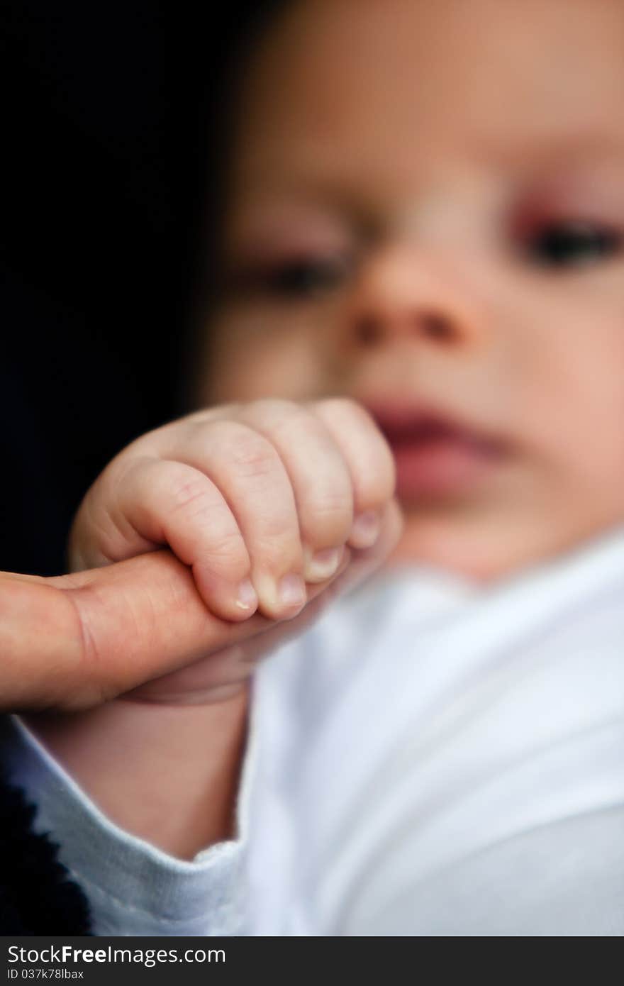 Baby's hand gripping adult finger. Baby's hand gripping adult finger.