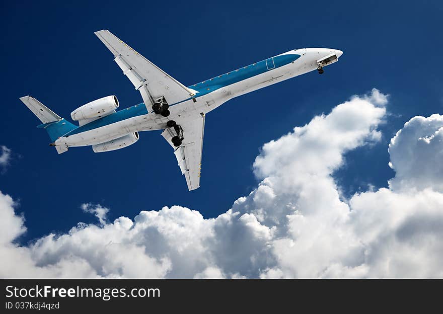 Big airliner in the blue sky with clouds.