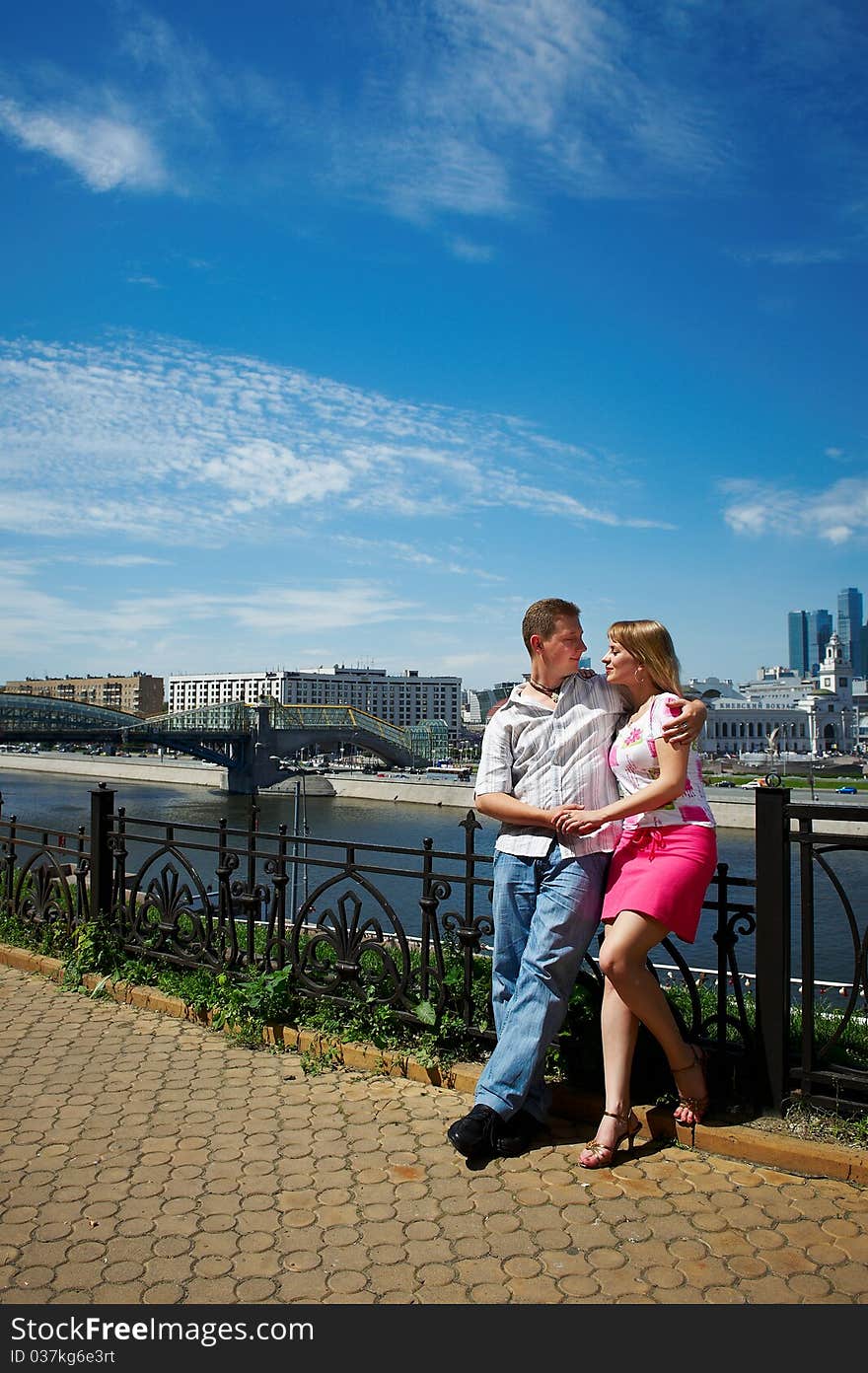 Young happy man and woman at romantic walk on the embankment of the Moskva River