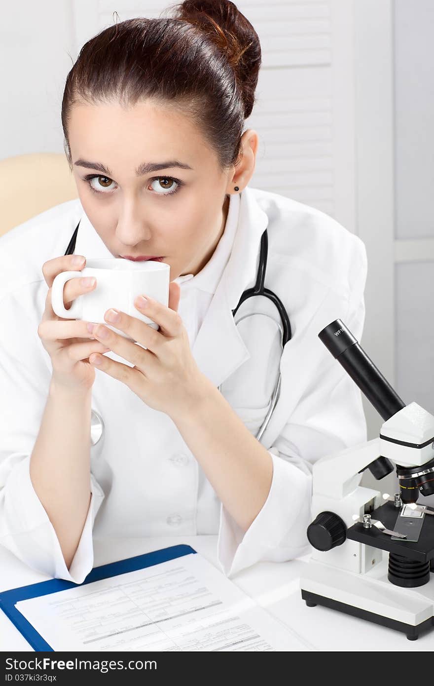 Female medical doctor working with a microscope. Female medical doctor working with a microscope