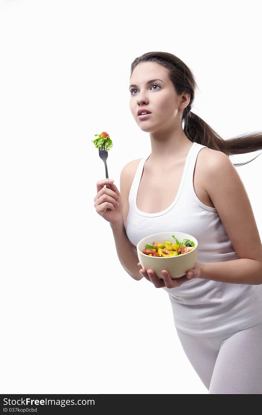 Attractive girl running with a plate of salad on a white background. Attractive girl running with a plate of salad on a white background