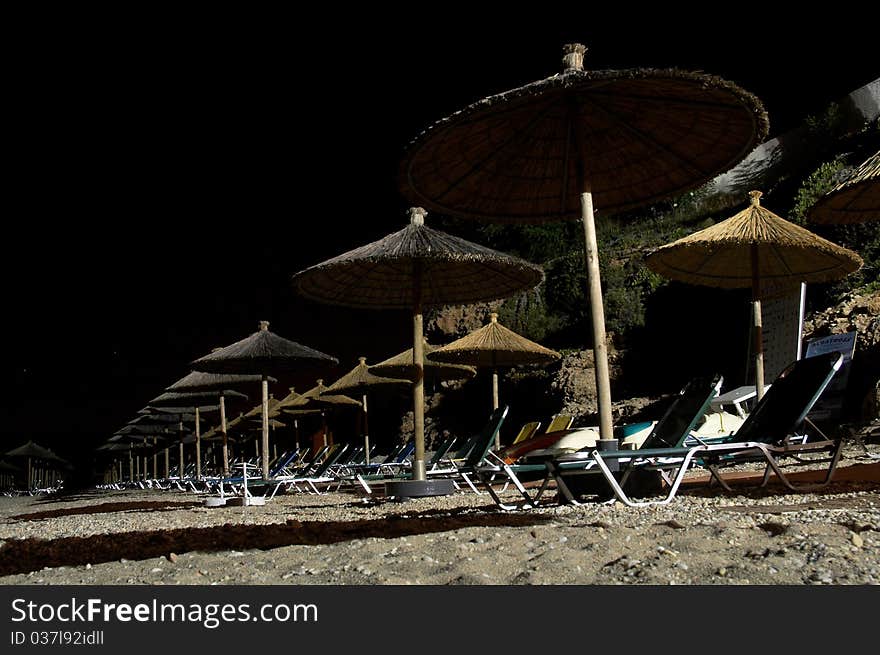 Beach umbrellas and chairs at night