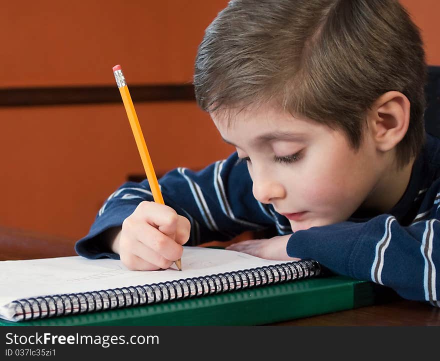 Young Boy Writing In Notebook