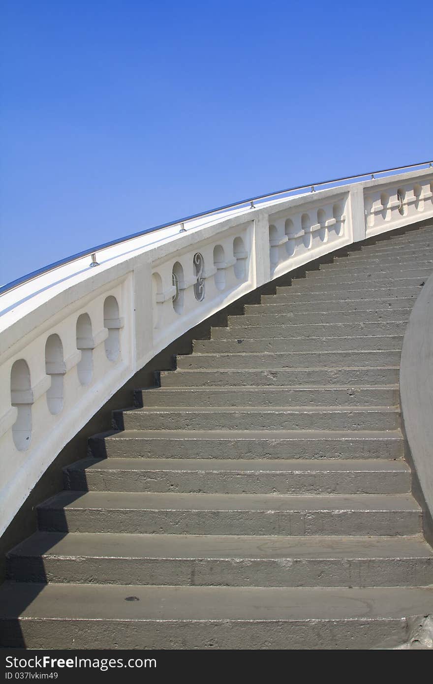 Old white stone circular stairs case in blue sky