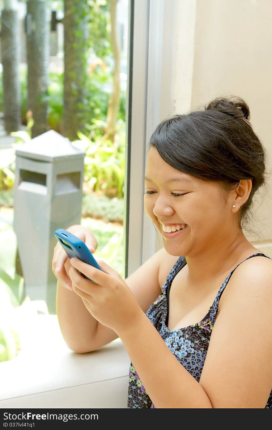 Asian ethnic young woman happy using cell phone. Asian ethnic young woman happy using cell phone