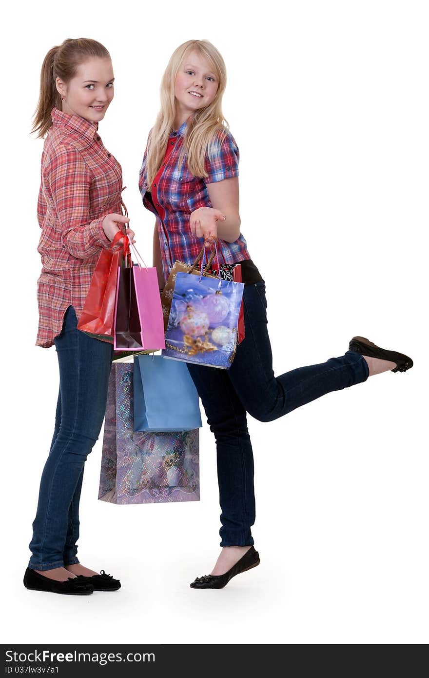 Two young beautiful girls on shopping on a white background