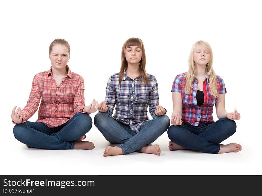 Three girls sitting in lotus posture on a white background