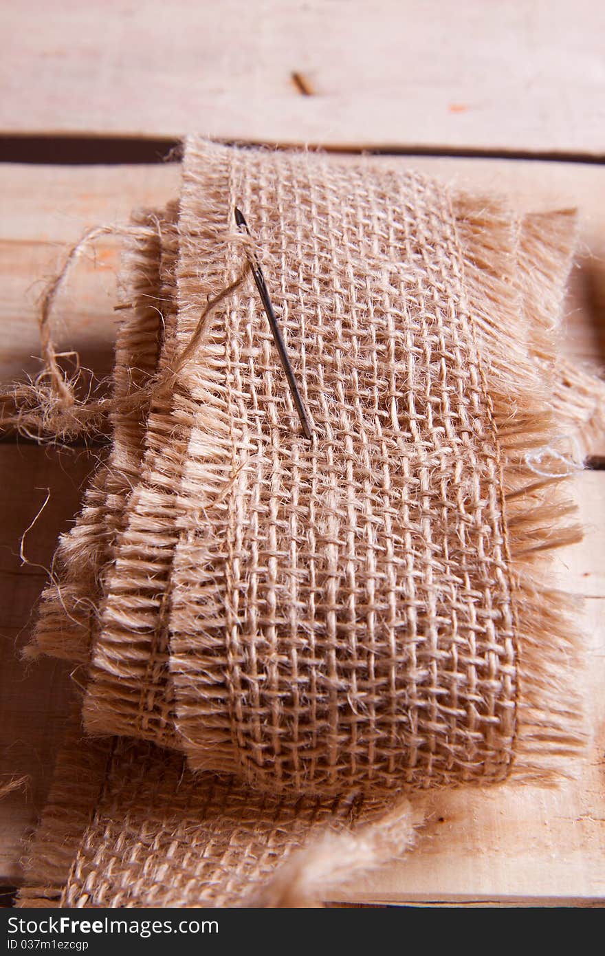 Needle and jute thread on wooden desk. Needle and jute thread on wooden desk