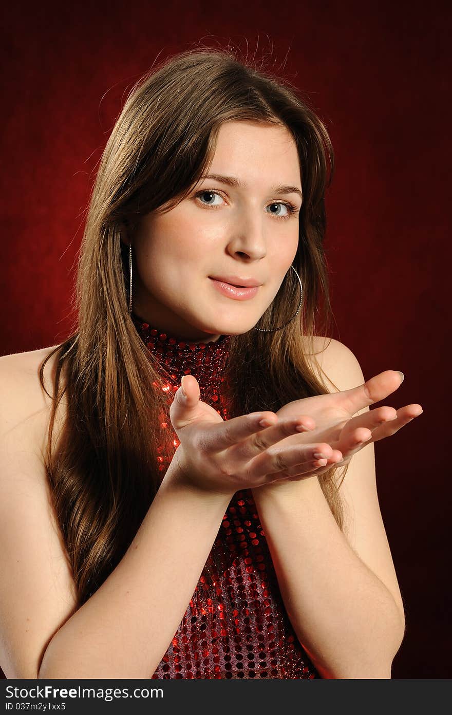 Young woman holding hand presenting a product.On a red background