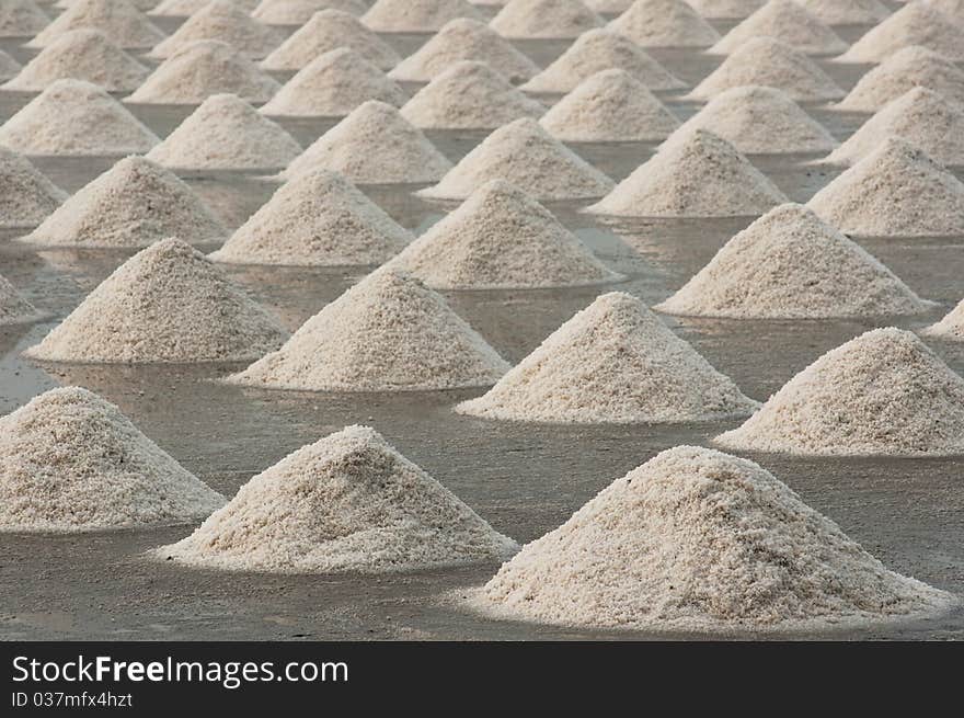 Saline in thailand . Farmer make heap of sea salt to preparation for packaging.