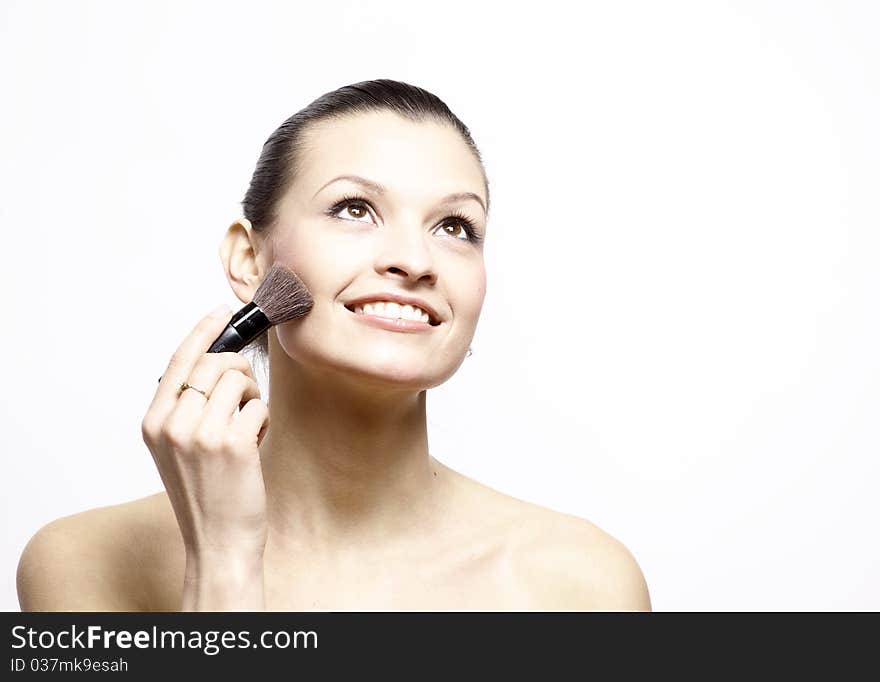 Portrait of attractive young woman applying blusher