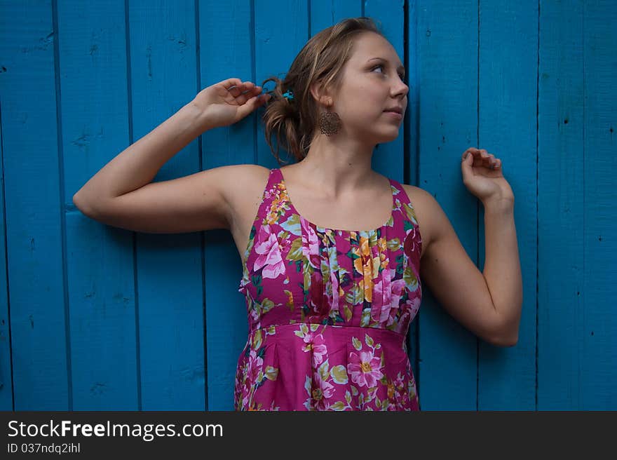 Girl in ethnic dress near blue wooden wall