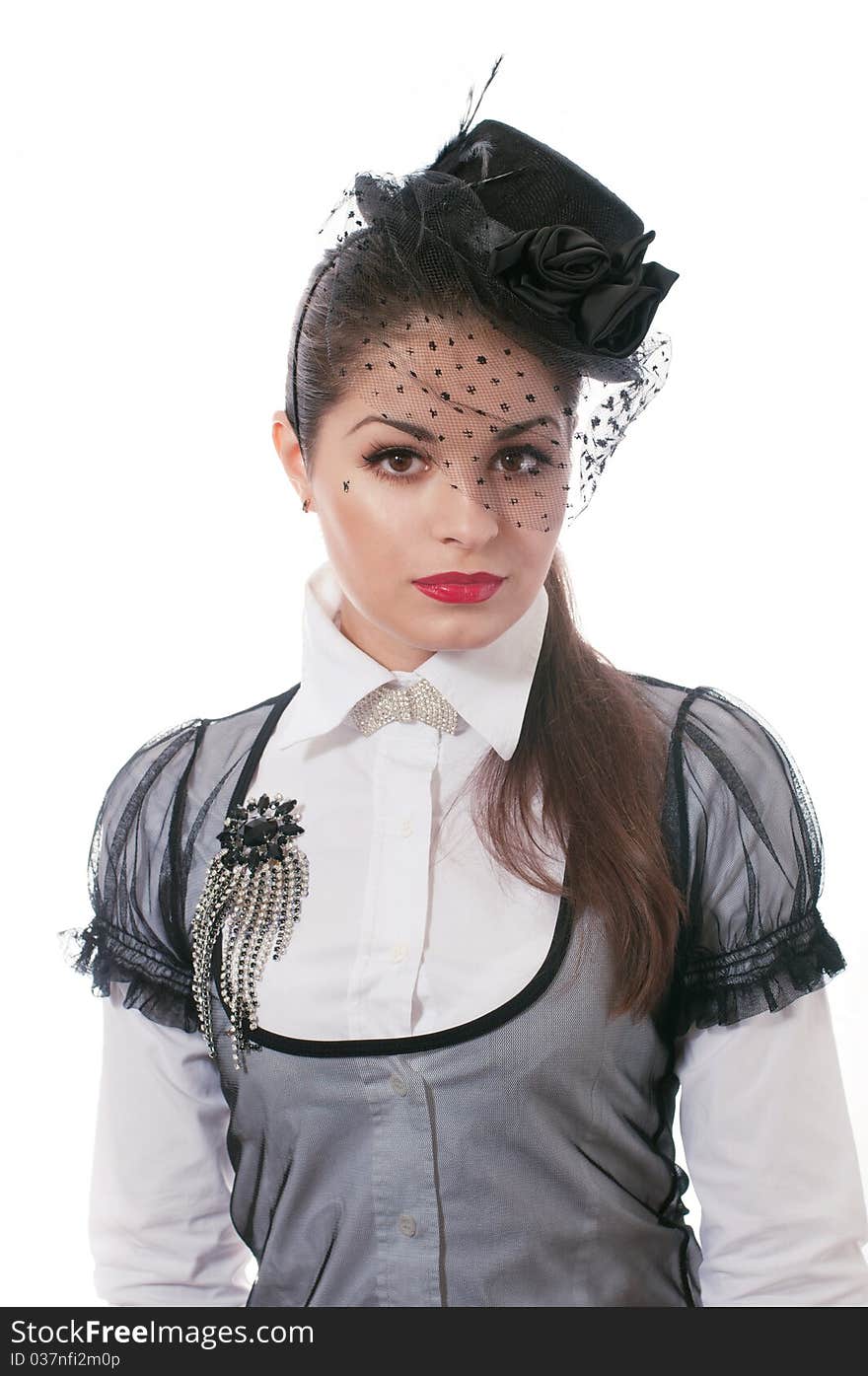 Portrait of young woman wearing the hat with a veil and white blouse with brooch on her breast. Portrait of young woman wearing the hat with a veil and white blouse with brooch on her breast