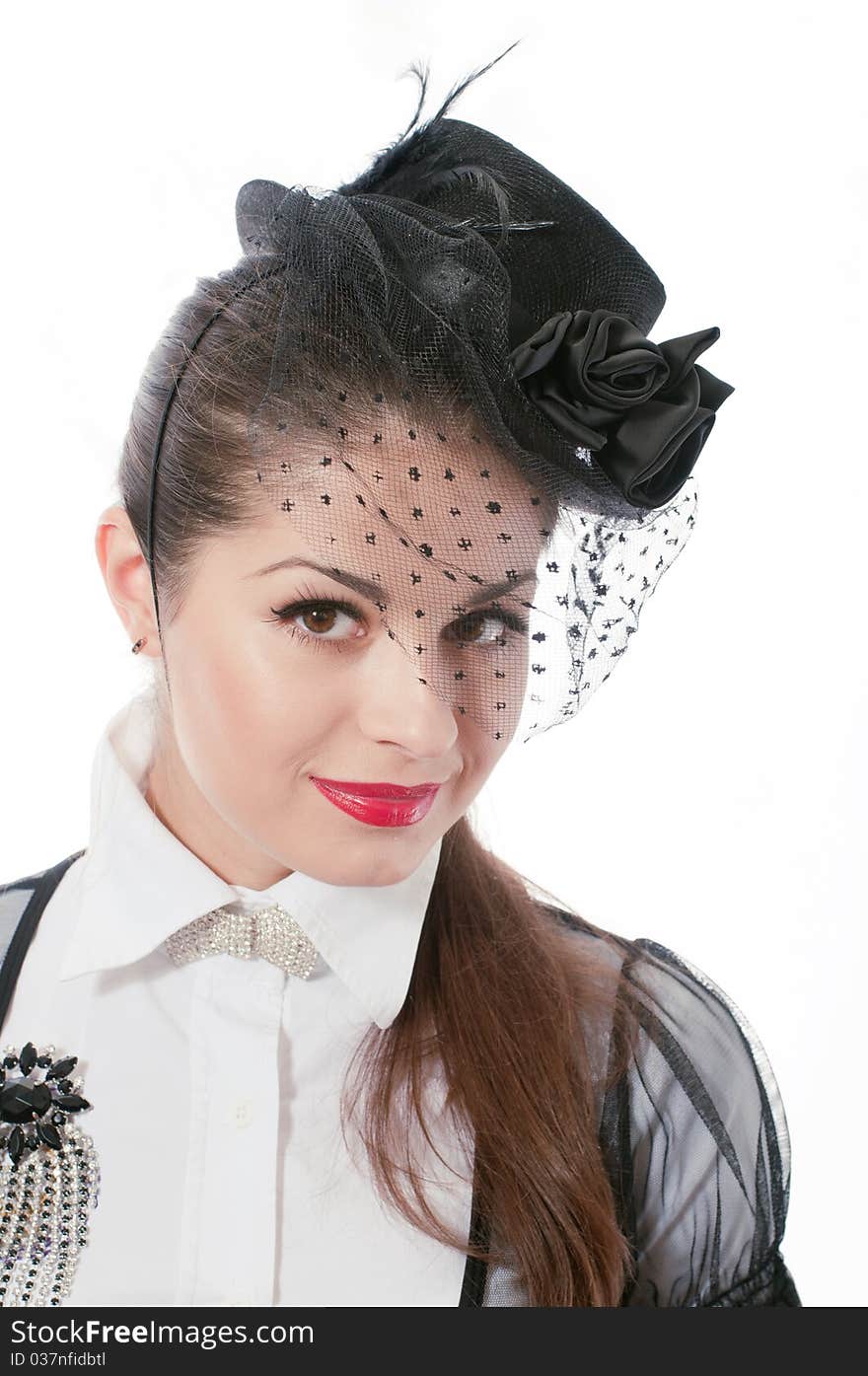 Portrait of young woman wearing the hat with a veil and white blouse with the brooch on her breast