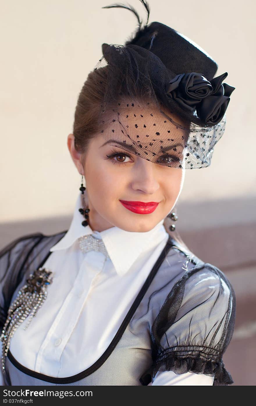 Portrait of a fresh and lovely woman wearing a hat with a veil and white blouse with a brooch on her breast. Portrait of a fresh and lovely woman wearing a hat with a veil and white blouse with a brooch on her breast