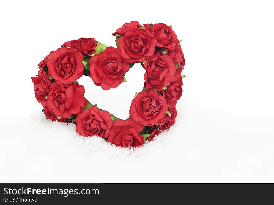 A red rose heart in the snow with lots of copy space, selective focus. A red rose heart in the snow with lots of copy space, selective focus