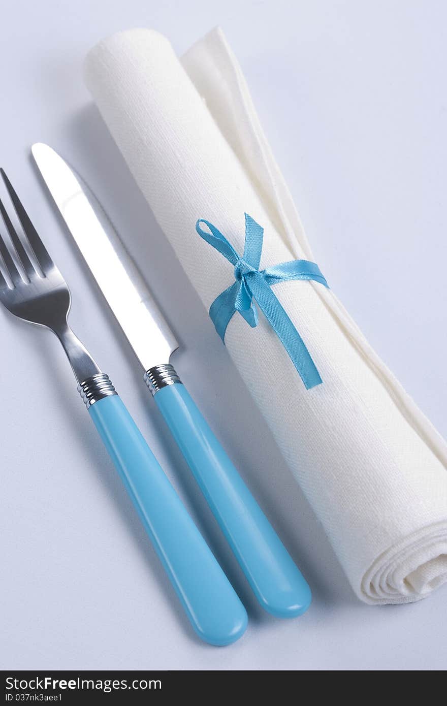 Table setting in blue and white with plates, napkin and silverware