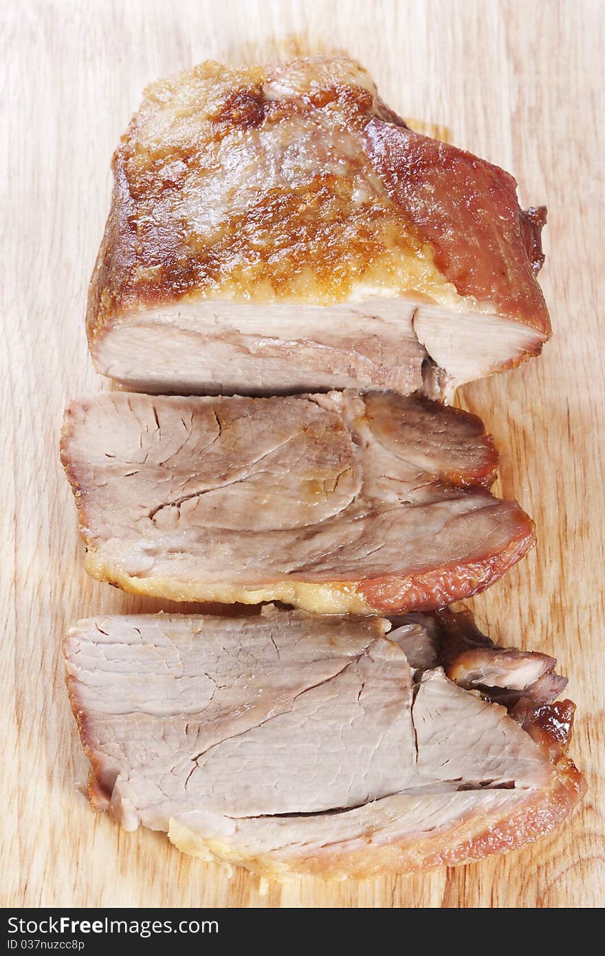 Roast pork shoulder sliced on a cutting board. Roast pork shoulder sliced on a cutting board