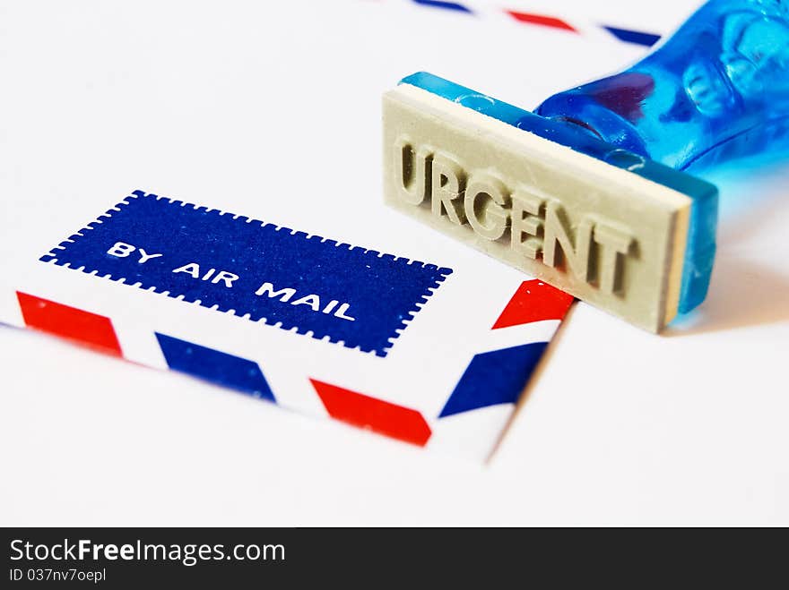 Urgent letter on rubber stamp on air mail envelope on white background. Urgent letter on rubber stamp on air mail envelope on white background