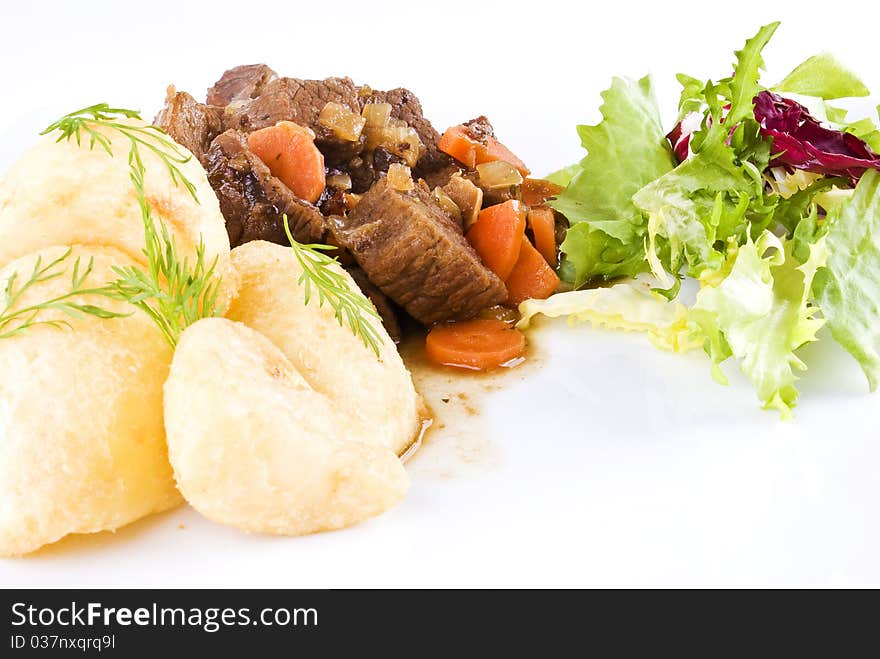 Stewed beef steak with potatoes and salad