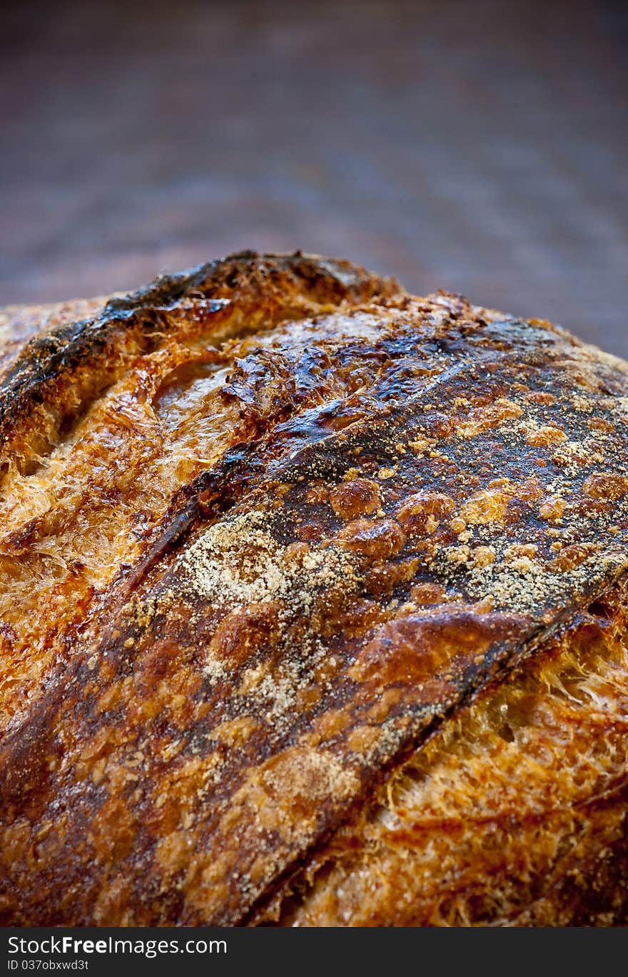 Close-Up of rustic sourdough bread on a wooden platter. Close-Up of rustic sourdough bread on a wooden platter