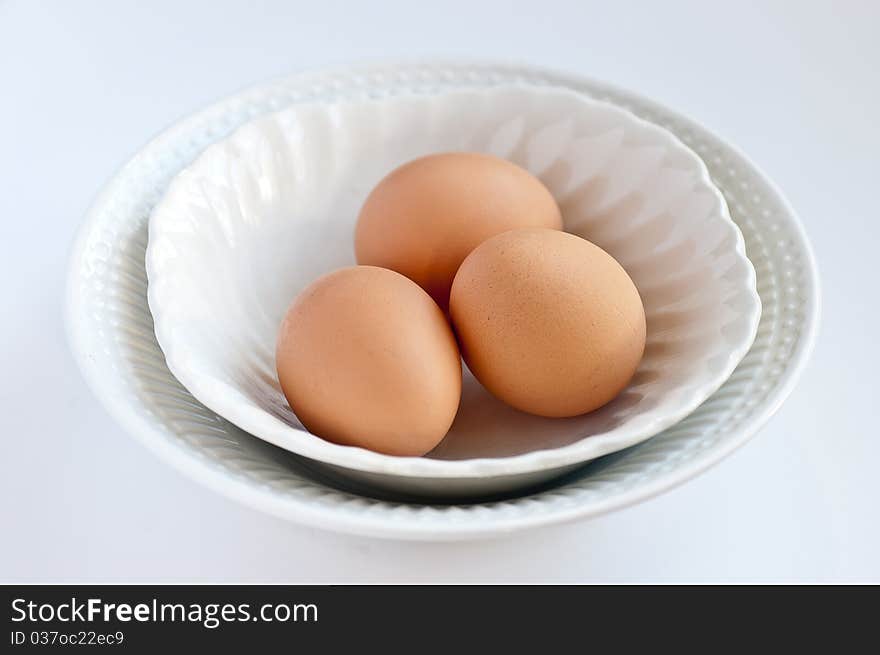 A white bowl full of organic eggs