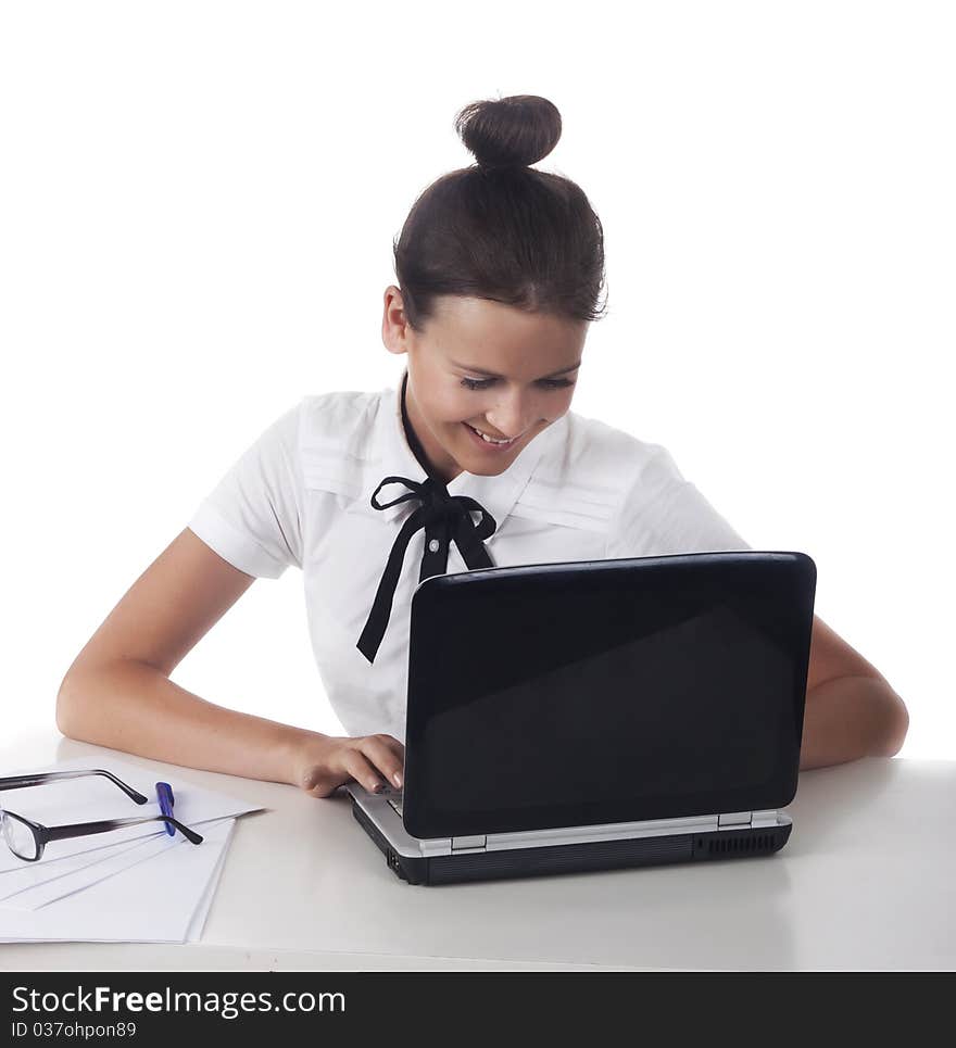 Woman with glasses sits at a table and working