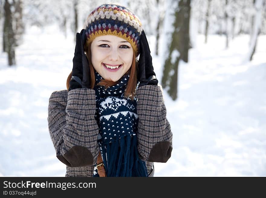 Beautiful young red-haired woman in winter park. Outdoor shot.